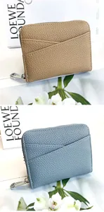 Detailed texture of litchi grain leather wallets in tan and blue with V-shaped card slots
