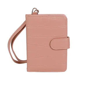 Detail of pink faux crocodile leather travel wallet with wristlet strap and golden metal ring
