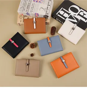 Flat lay of colorful pebble leather short wallets with round metal buckle decoration