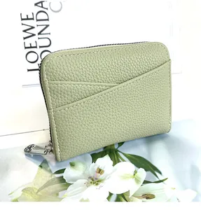 Close-up of grass green litchi grain leather card holder with multiple slots and metal zipper