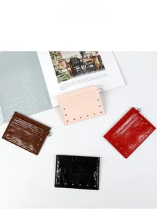 Flat lay of textured leather card holders in four colors with stylish metal rivet details