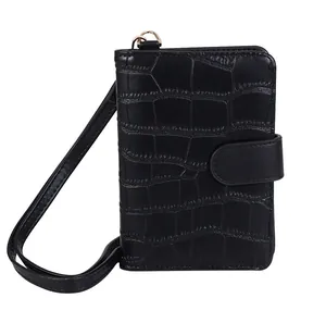 Close-up of black crocodile pattern passport holder with snap closure and wrist strap
