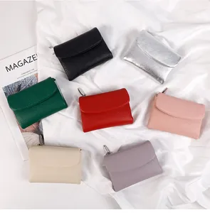 Vue à plat de plusieurs portefeuilles en cuir grainé colorés avec zip en métal