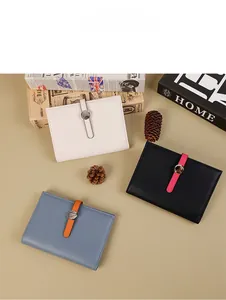 Litchi texture leather passport wallets in cream, black, and blue with metal buckles
