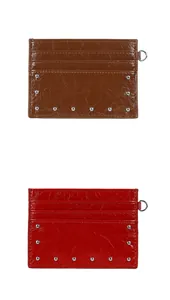 Detail of red and brown card holders with crinkle patent texture and silver rivets