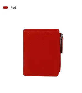 Detailed macro shot of red pebbled leather wallet featuring silver zipper and neat stitching
