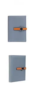Detail of lychee pattern leather passport wallet with contrast orange buckle and metal accent