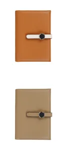 Close-up of litchi pattern leather passport wallets in orange and taupe colors