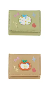 Detail of cute trifold wallets with lychee leather texture and 3D apple embroidery