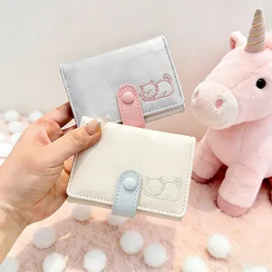 Detail of cute cat pattern wallets in silver and beige with textured material and buckles