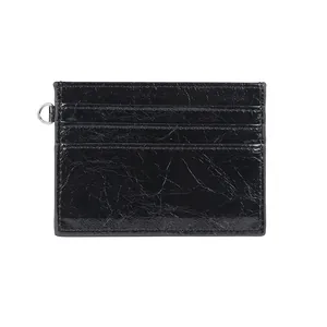 Minimalist black wrinkled leather card holder with metallic D-ring and rivet details