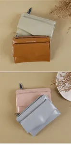 Détail de quatre portefeuilles en cuir colorés avec design enveloppe et fermeture éclair