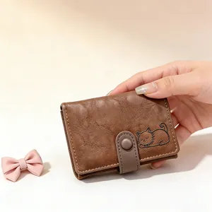 Close-up of brown textured leather trifold wallet featuring a sleeping cat line art pattern