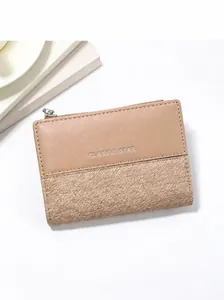 Short khaki patchwork wallet with silver zipper on a modern minimalist display stand
