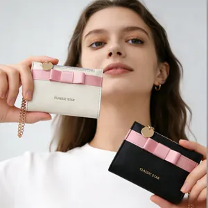 Minimalist macaron color bow wallets in cream and black with elegant gold zipper and chain