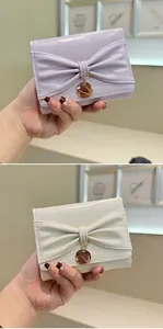 Détail de portefeuilles brillants violet clair et beige avec nœuds et pendentifs