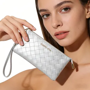 Close-up of woven silver texture clutch bag featuring metallic finish and gold zipper detail