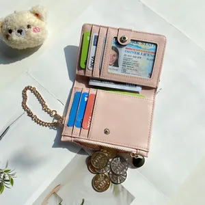 Detail of pink PU leather wallet with multiple card slots and gold chain charm