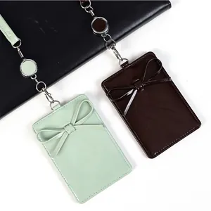 Porta badge in pelle PU con fiocco e cordino retrattile nei colori verde menta e marrone