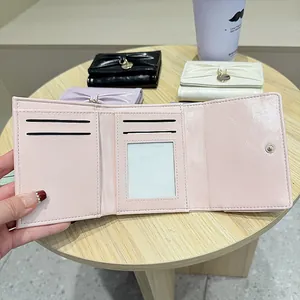 Portefeuille femme à trois volets avec nœud en cuir verni et fentes pour cartes