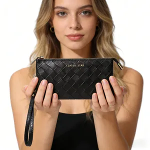 Detail of black woven leather clutch with gold logo, zipper closure and wrist strap
