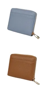Detail of lychee pattern leather wallets in light blue and brown with gold zippers
