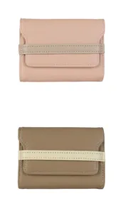 Dettaglio di porta carte a fisarmonica in pelle rosa e marrone con trama a grana fine