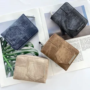 Flat lay of denim textured zipper wallets in four colors on magazine and palm leaf