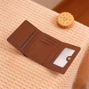 Interior detail of a brown tri-fold wallet showing card slots and transparent ID window