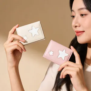 Detail of mini trifold wallets in beige and pink with decorative star patterns