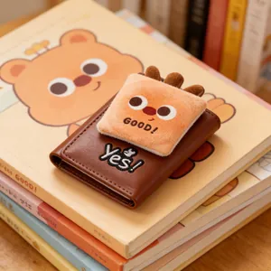 Close-up of brown leather card holder featuring plush bear patch and fine embroidery