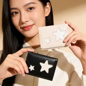 Close-up of minimalist bi-fold wallets featuring leather star patchwork in black and cream
