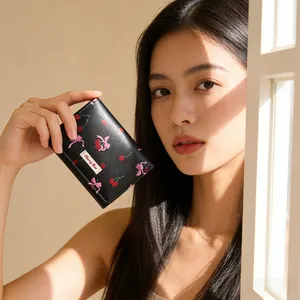 Close-up of black leather cherry and bow print wallet with stitched Cherry Bee label