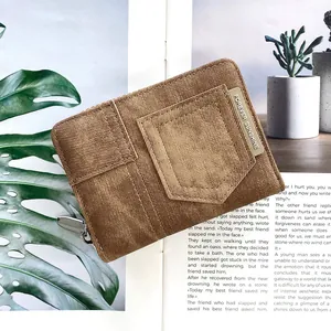 Detailed view of brown denim texture wallet with golden logo and zipper closure