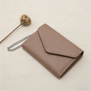 Close-up of litchi grain leather mini wallet with silver chain strap and V-shaped stitching