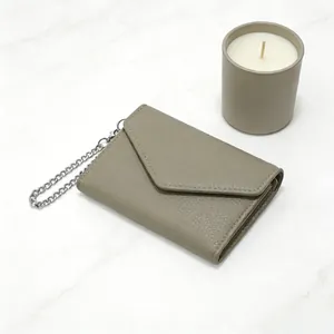 Detail of taupe litchi grain leather wallet with envelope flap and silver chain
