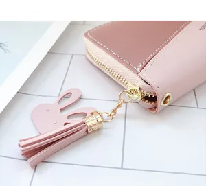 Détail du portefeuille patchwork rose et marron avec breloque lapin et zip doré