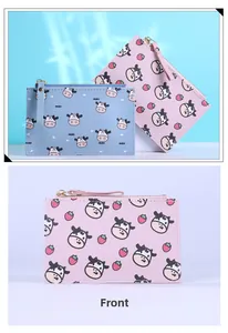 Detail view of slim cartoon cow print card wallets in light blue and pink with gold zippers