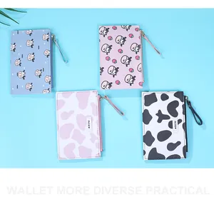 Flat lay view of four cute cow and cat print slim zip wallets with wristlet straps