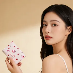 Close-up of pink cherry and bow print wallet held by hand showing leather detail