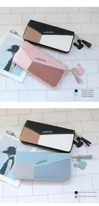 Détail de portefeuilles longs colorblock avec pompons et breloques lapin sur une table
