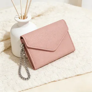 Close-up of litchi pattern leather wallet in dusty pink with silver chain detail