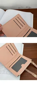 Detail view of pink PU leather wallet with internal card slots and gold zipper