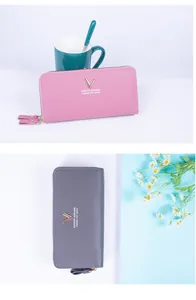 Close-up of double zipper PU leather wallet with metallic V-logo and pebbled texture