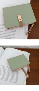 Detail of light green litchi texture PU leather wallet with gold zipper and card slots