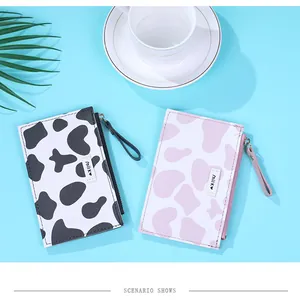 Detail of cow print card holders with milk labels and wrist straps in blue setting