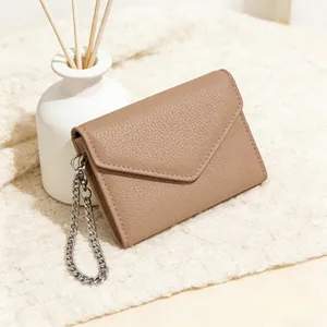 Detail of khaki pebbled leather envelope wallet with silver chain on knit fabric