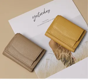 Detailed macro view showing lychee pattern texture on leather wallets in beige and yellow