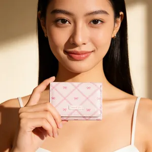 Gros plan du portefeuille rose à nœuds avec étiquette Sweet Girl sous la lumière