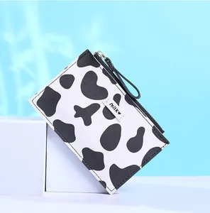 Detailed close-up of cow print slim wallet with zipper and milk label decoration